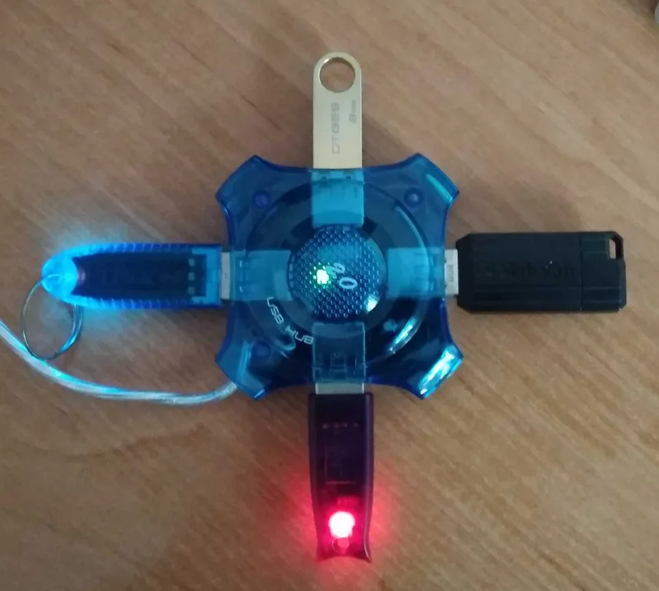 Translucent blue four-port Gembird USB hub with USB devices plugged into its ports